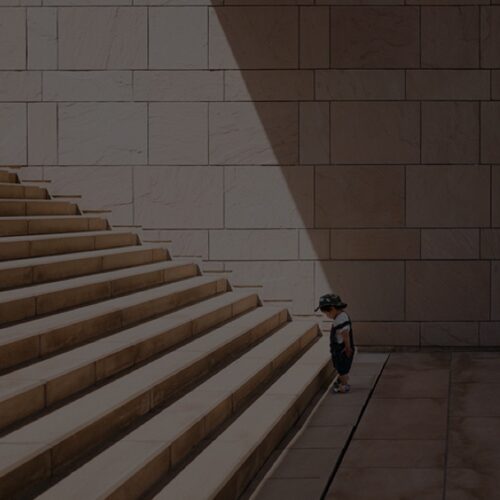 Child standing at foot of wide stone steps